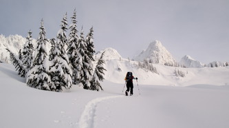 Lindsay breaking trail with Shuksan Arm in the distance