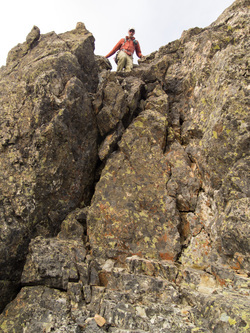 Franklin preparing to descend the short section of class 4 on the summit block of Iapia Peak.