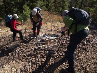 Lindsay, Matt, and Tom examine a trash cache.  MREs, sitting pad, candy, it was kind of interesting.  We packed most of it out.